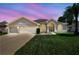 Charming single-story home featuring a manicured lawn, arched windows, and a spacious two-car garage at 9219 Irondale Ln, Hudson, FL 34667
