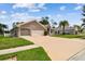 Well-maintained single-story home featuring a manicured lawn, arched windows, and a spacious two-car garage at 9219 Irondale Ln, Hudson, FL 34667