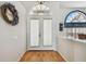 Inviting hallway featuring hardwood floors, transom window and decorative wreath at 9219 Irondale Ln, Hudson, FL 34667