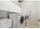 Efficient laundry room featuring front-load washer/dryer, utility sink, and overhead storage at 9219 Irondale Ln, Hudson, FL 34667