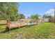 This backyard features a large deck, pool, green yard and well-manicured trees at 9616 56Th N St, Pinellas Park, FL 33782