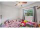 This cozy bedroom is well-lit and contains a ceiling fan and a window to the outside at 9616 56Th N St, Pinellas Park, FL 33782