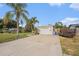 Exterior view of the single car garage and the driveway with lush landscaping around the house at 9616 56Th N St, Pinellas Park, FL 33782