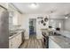 Modern kitchen with white cabinets, stainless steel appliances, granite countertops and wood style tile flooring at 9616 56Th N St, Pinellas Park, FL 33782