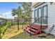 Backyard space with stairs leading to the house. Fenced in yard, grass, and nearby buildings at 113 Bosphorous Ave # 5, Tampa, FL 33606