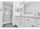 Modern bathroom with walk-in shower, double vanity, grey wood-look tile and white paint at 113 Bosphorous Ave # 5, Tampa, FL 33606