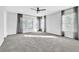 Spacious bedroom with carpet, ceiling fan, and three windows with curtains and blinds at 113 E Bosphorous Ave # 5, Tampa, FL 33606