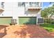 View of two-car garage with green doors and brick driveway of charming townhome with balcony at 113 Bosphorous Ave # 5, Tampa, FL 33606