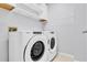 Bright laundry room featuring a Whirlpool washer and dryer and built-in shelving for convenient storage at 113 Bosphorous Ave # 5, Tampa, FL 33606
