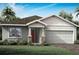 Charming single-story home featuring a two-car garage, manicured lawn, and a welcoming red front door at 12305 49Th E St, Parrish, FL 34219
