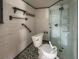 Bathroom in need of renovation, showcasing a toilet, shower, and patterned flooring at 13326 1St E St, Madeira Beach, FL 33708
