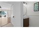 Contemporary bathroom with stylish vanity, round mirror, and modern lighting fixtures with access to living area at 13751 Juniper Blossom Dr, Tampa, FL 33618