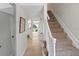 Spacious hallway with tile floors leading to a staircase and living spaces, filled with natural light at 13751 Juniper Blossom Dr, Tampa, FL 33618