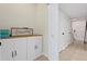 Hallway with storage cabinets, tile flooring, and access to other rooms with multiple access doors at 13751 Juniper Blossom Dr, Tampa, FL 33618