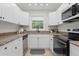 Bright kitchen featuring granite countertops, stainless steel appliances, and white cabinetry with black hardware at 13751 Juniper Blossom Dr, Tampa, FL 33618