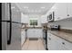 Modern kitchen featuring stainless steel appliances, granite countertops, and sleek white cabinetry at 13751 Juniper Blossom Dr, Tampa, FL 33618