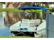 A pontoon boat sits near the water's edge, offering relaxing views and water activities in a peaceful setting at 13751 Juniper Blossom Dr, Tampa, FL 33618