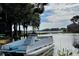 Scenic waterfront view featuring a boat, lush trees, and a serene body of water under a partially cloudy sky at 13751 Juniper Blossom Dr, Tampa, FL 33618