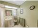 Bathroom featuring a pedestal sink, a skylight, and tiled walls for a clean and bright space at 13821 Joyce Dr, Largo, FL 33774