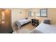 Bedroom with two twin beds, light yellow walls, and an area rug at 13821 Joyce Dr, Largo, FL 33774