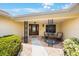 Inviting covered front porch with seating area, brick-paved walkway, and decorative foliage at 13821 Joyce Dr, Largo, FL 33774