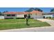 Charming single-story home with a terracotta roof, an attached garage, and a manicured front lawn at 13821 Joyce Dr, Largo, FL 33774
