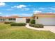 Eye-level view of the home's manicured front lawn and garden, accented with shrubbery and a paved walkway at 13821 Joyce Dr, Largo, FL 33774