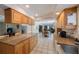 Open kitchen featuring wooden cabinetry, granite counters, and tile flooring adjacent to the Gathering room at 13821 Joyce Dr, Largo, FL 33774
