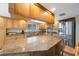 Updated kitchen with wooden cabinetry, granite countertops, a large island, and stainless steel refrigerator at 13821 Joyce Dr, Largo, FL 33774