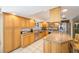 Updated kitchen with wooden cabinets, granite countertops, stainless steel appliances, and tile flooring at 13821 Joyce Dr, Largo, FL 33774