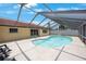 Backyard pool with screened enclosure, tile deck, and easy access to the house at 13821 Joyce Dr, Largo, FL 33774