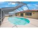 Clear blue pool in a screened enclosure with dining area and well-maintained patio at 13821 Joyce Dr, Largo, FL 33774