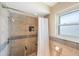 Walk-in shower with tiled walls, a rainfall showerhead, and a built-in niche for toiletries at 13821 Joyce Dr, Largo, FL 33774