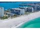 An aerial view showcases condos and beach homes alongside a pristine beach and clear blue waters at 1400 Gulf Blvd # 804, Clearwater Beach, FL 33767