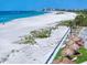 Scenic aerial view of a beach, tiki huts, and condo building on a sunny day at 1400 Gulf Blvd # 804, Clearwater Beach, FL 33767