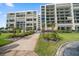 Beautiful condo building with well-manicured landscaping and a walkway leading to the entrance at 1400 Gulf Blvd # 804, Clearwater Beach, FL 33767