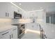 Bright, fully renovated kitchen with white cabinets, stainless steel appliances, and stylish countertops at 1400 Gulf Blvd # 804, Clearwater Beach, FL 33767