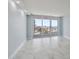 Bright living room features light blue walls, marble floors and sliding glass doors to balcony overlooking water views at 1400 Gulf Blvd # 804, Clearwater Beach, FL 33767