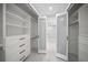 This spacious walk-in closet features custom shelving and drawers with an adjoining secondary room at 1400 Gulf Blvd # 804, Clearwater Beach, FL 33767
