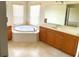 Bathroom featuring soaking tub, dual sinks, and tile flooring at 1503 Citrine Trl, Tarpon Springs, FL 34689
