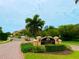 Welcoming entrance to Sunset Bay Townhomes with a decorative sign and well-maintained landscaping at 1503 Citrine Trl, Tarpon Springs, FL 34689