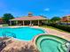 Community pool and spa with lounge chairs and clubhouse offering a perfect spot for relaxation at 1503 Citrine Trl, Tarpon Springs, FL 34689