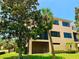 Exterior view of a tan multi-story home with a screened-in patio at 1503 Citrine Trl, Tarpon Springs, FL 34689