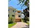 Multi-story townhome features a tile roof, balcony, and attached garage with a brick driveway at 1503 Citrine Trl, Tarpon Springs, FL 34689
