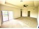 Bright living room features sliding doors leading to a patio, and neutral carpet at 1503 Citrine Trl, Tarpon Springs, FL 34689