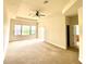 Spacious living room features plush carpet, a ceiling fan, and a large window for natural light at 1503 Citrine Trl, Tarpon Springs, FL 34689
