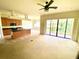Open-concept living area connected to the kitchen, featuring a ceiling fan and sliding glass doors to the balcony at 1503 Citrine Trl, Tarpon Springs, FL 34689