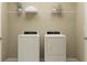 Functional laundry room with washer and dryer, plus storage shelves for organization at 15091 Zircon Red Dr, Wimauma, FL 33598