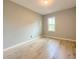 A bright bedroom with a wood-look laminate floor, a neutral wall color and a large window at 1536 S Martin Luther King Jr Ave, Clearwater, FL 33756