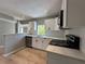 Modern kitchen with white cabinets, marble countertops, stainless steel appliances, and wood-look floors at 1536 S Martin Luther King Jr Ave, Clearwater, FL 33756